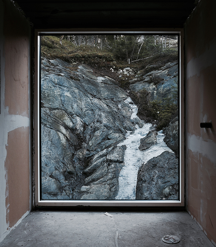 Master bath under construction and as finished result. The bathroom faces the exposed rock at the rear of the house